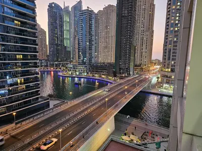 a city with a bridge over a river with buildings at Cozy Studio - Dubai Marina - 5 Min to Beach and Metro in Dubai