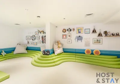 a childs room with a green carpeted floor at Unique 1BR in Belgravia Square, JVC - Host & Stay in Dubai