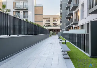a row of benches on a sidewalk in front of buildings at Unique 1BR in Belgravia Square, JVC - Host & Stay in Dubai