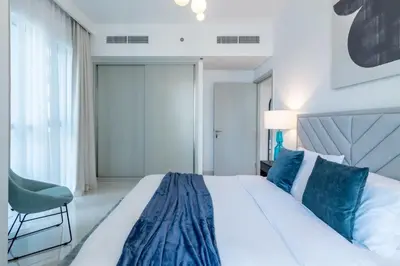 a bedroom with a large bed and a chair at Apartments Beach Isle Tower, 1BR in Dubai