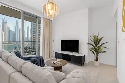 a white living room with a couch and a tv at Apartments Beach Isle Tower, 1BR in Dubai