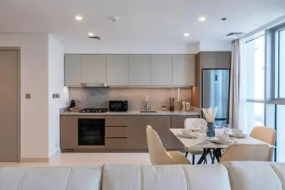 a kitchen with a white couch and a table with chairs at Apartments Beach Isle Tower, 1BR in Dubai