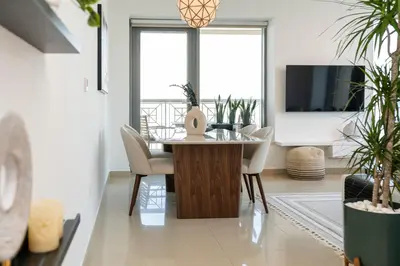 a dining room with a table and chairs and a tv at Prestige Living 2BR with Full Burj Khalifa and Fountain View by Auberge in Dubai