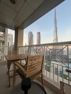 a balcony with a wooden bench and a view of the city at Prestige Living 2BR with Full Burj Khalifa and Fountain View by Auberge in Dubai