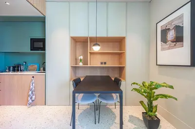 a dining room with a table and a plant at Studio with Burj Khalifa View - Upside Living in Dubai