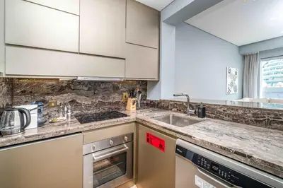 a kitchen with white cabinets and a sink at Luxurious Escape meets Fendi Design in Iconic Building on Top Location in Dubai Marina in Dubai