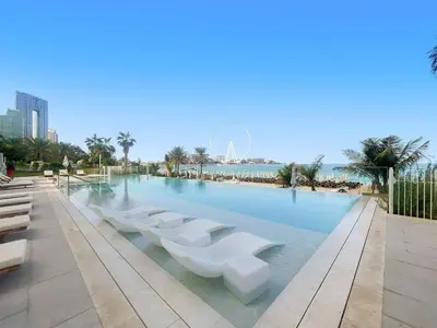 a large swimming pool with white seats in the water at 3Bed Private Beach - Belle vie à La Vie Dubai in Dubai