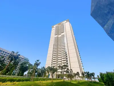 a tall building with palm trees in front of it at Elegant and Modern 1BR Apt in JBR with Beach Access in Dubai