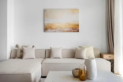 a living room with a white couch and a painting at Amazing 2br with a lagoon view in Creek Harbour in Dubai