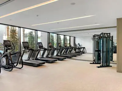a gym with a row of treadmills and machines at Amazing 2br with a lagoon view in Creek Harbour in Dubai