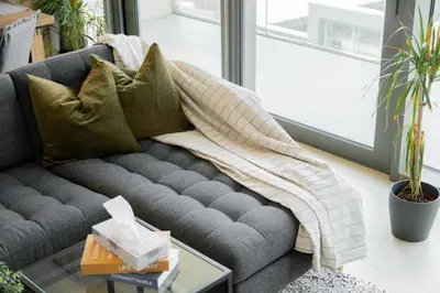 a grey couch with pillows on it in a living room at Elite Escape Holiday Home - 3 BHK Getaway with Burj Khalifa View and Dubai Mall Access - 1505 in Dubai