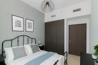 a bedroom with a bed and a chandelier at Elite Escape Holiday Home - 3 BHK Getaway with Burj Khalifa View and Dubai Mall Access - 1505 in Dubai