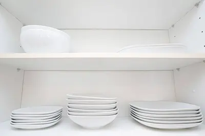 a group of white plates and bowls on a shelf at New Arabian Shams 2 JBR Sea View in Dubai