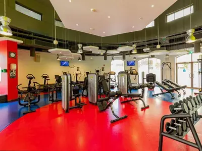 a gym with several tread machines on a red floor at New Arabian Shams 2 JBR Sea View in Dubai