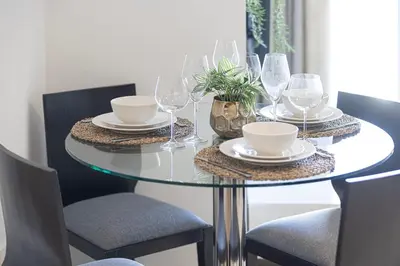 a dining room table with glasses and plates and chairs at Whispers of the Wind by Lagom Vacation Homes in Dubai