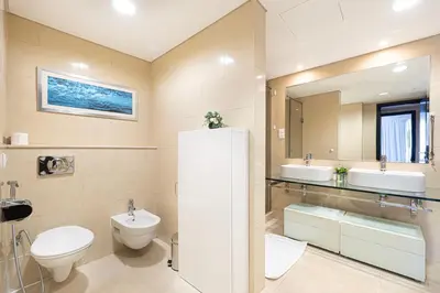 a bathroom with a toilet and a sink and a mirror at Whispers of the Wind by Lagom Vacation Homes in Dubai