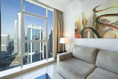 a living room with a couch and a large window at Whispers of the Wind by Lagom Vacation Homes in Dubai