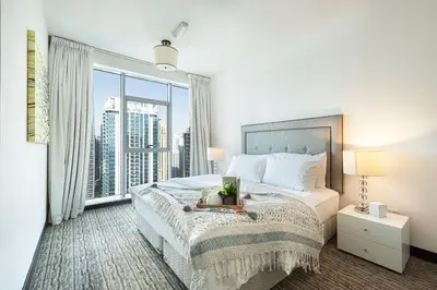 a bedroom with a bed and a large window at Whispers of the Wind by Lagom Vacation Homes in Dubai