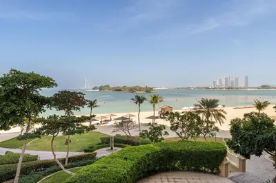 a view of the beach from the balcony of a resort at Luxury Living w private beach and Burj AlArab view in Dubai