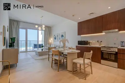 a kitchen and living room with a table and chairs at Mira Holiday Homes - Newly 1 bedroom with sea view in Dubai