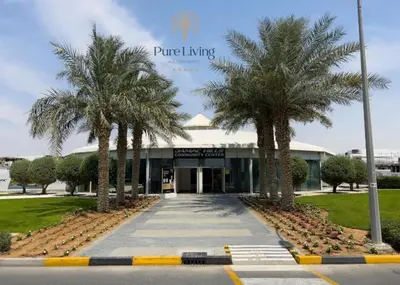 a building with palm trees in front of it at Damac Hills Carson C studio with full kitchenet - Ideal for monthly stay in Dubai