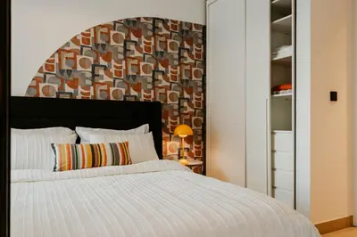 a bedroom with a white bed with a large headboard at Coolest 1 BR in Dubai Hills close to the Park in Dubai