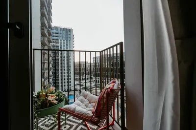 a balcony with a chair and a view of a city at Coolest 1 BR in Dubai Hills close to the Park in Dubai