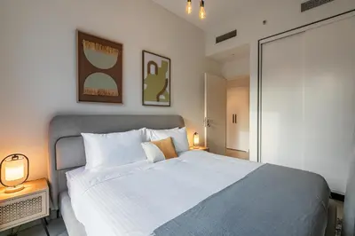 a bedroom with a large white bed with two lamps at Upgraded Interior I Dubai Hills I City View I Socio Tower in Dubai