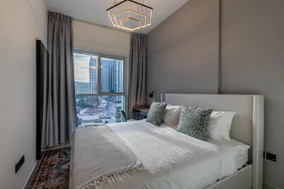 a bedroom with a bed and a large window at Upgraded Interior I Dubai Hills I City View I Socio Tower in Dubai