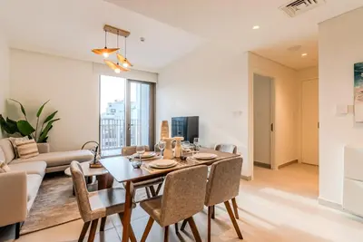 a dining room and living room with a table and chairs at Coastal Vibe I 1BDR apartment in Creek Beach I Summer 2 in Dubai