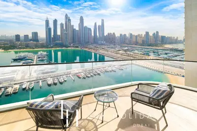 a balcony with chairs and a view of the city at LUX The Marina Vista Beachfront Suite in Dubai