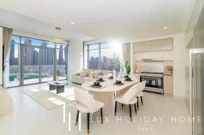 a kitchen and living room with a table and chairs at LUX The Marina Vista Beachfront Suite in Dubai