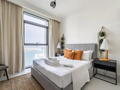 a bedroom with a large bed and a large window at Sea-Front Unique Retreat With Balcony in Marina in Dubai