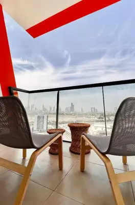 a balcony with two chairs and a view of the city at Stylish & Roomy 1BR in the Heart of the City in Dubai