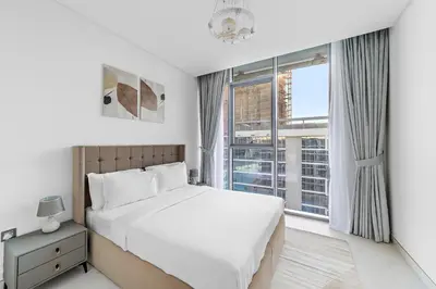 a bedroom with a bed and a large window at ALiving Classy 2BR I Lagoons View I District One Residence 7 in Dubai