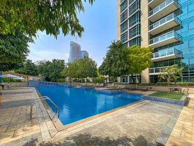 a swimming pool in front of a building at ALiving Classy 2BR I Lagoons View I District One Residence 7 in Dubai