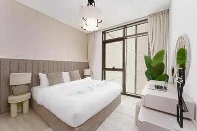 a bedroom with a large white bed and a window at Luxe 1-Bedroom Elegance in Palace Residences in Dubai