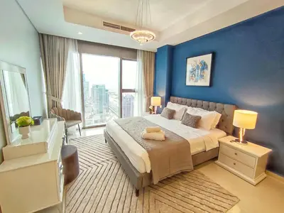 a bedroom with a large bed with blue walls at White Sage - Deluxe Apartment With Unobstructed Sea Views in Dubai