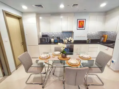 a kitchen with a dining room table and chairs at White Sage - Deluxe Apartment With Unobstructed Sea Views in Dubai