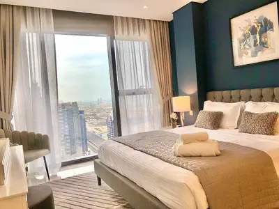 a bedroom with a large bed with a large window at White Sage - Deluxe Apartment With Unobstructed Sea Views in Dubai