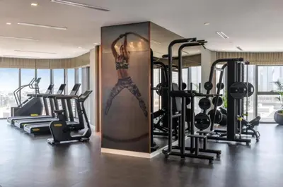 a gym with a painting of a woman on the wall at White Sage - Deluxe Apartment With Unobstructed Sea Views in Dubai