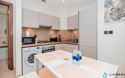 a kitchen with a table with water bottles on it at Inviting 2BR Apartment - Only 10 Mins to Downtown - Sobha Creek Vista Reserve in Dubai