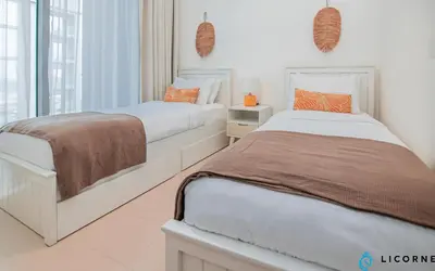 two beds in a white bedroom with a window at Inviting 2BR Apartment - Only 10 Mins to Downtown - Sobha Creek Vista Reserve in Dubai