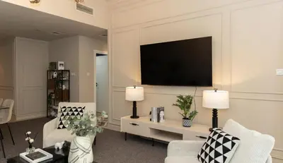 a living room with two chairs and a tv at Prime Spacious 2 BR Apt, Burj Khalifa & Canal View - Scala Tower in Dubai