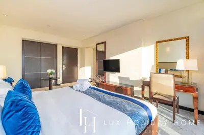 a hotel room with a bed and a desk and a television at LUX The JW Marina Studio in Dubai