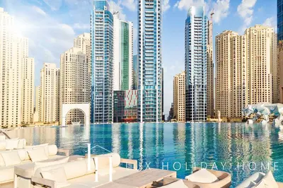 a large swimming pool in a city with tall buildings at LUX The JW Marina Studio in Dubai