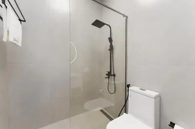 a bathroom with a shower with a toilet and a shower head at Extraordinary Loft Living in JVC by Suiteable in Dubai