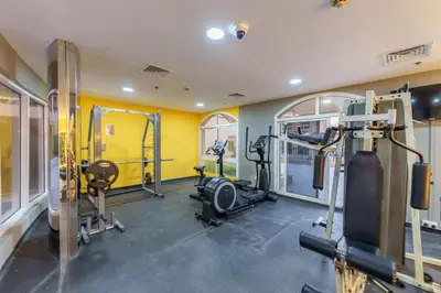 a gym with several treadmills and machines in a room at Extraordinary Loft Living in JVC by Suiteable in Dubai