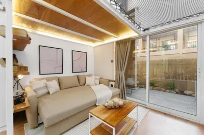 a living room with a bed and a large window at Extraordinary Loft Living in JVC by Suiteable in Dubai