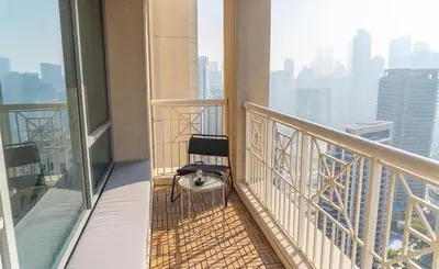 a chair sitting on the balcony of a building at Downtown Oasis, Burj Khalifa Views, Luxury Amenities in Dubai